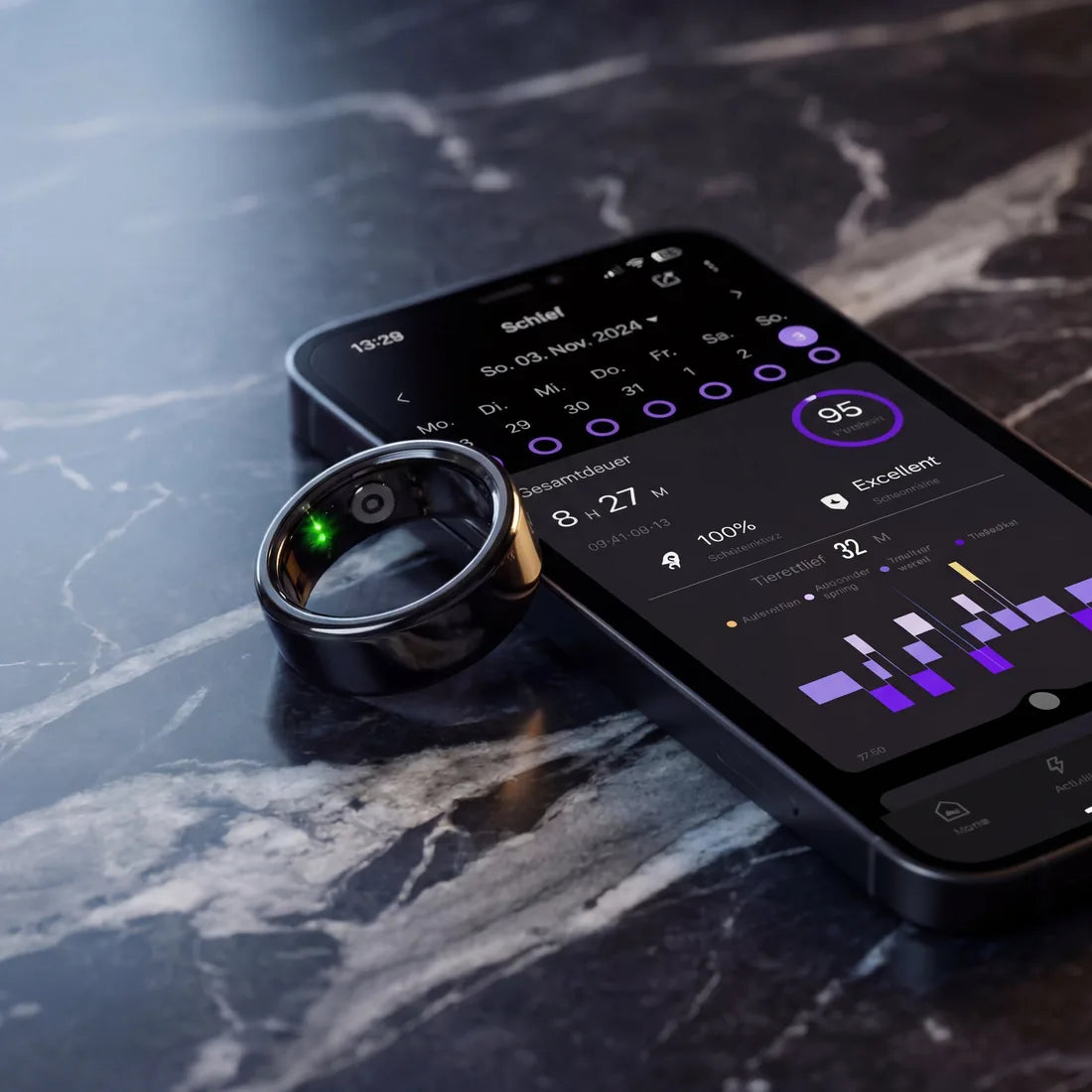 Lunaring in Silber neben iPhone mit Lunaring App auf dunklem Marmor